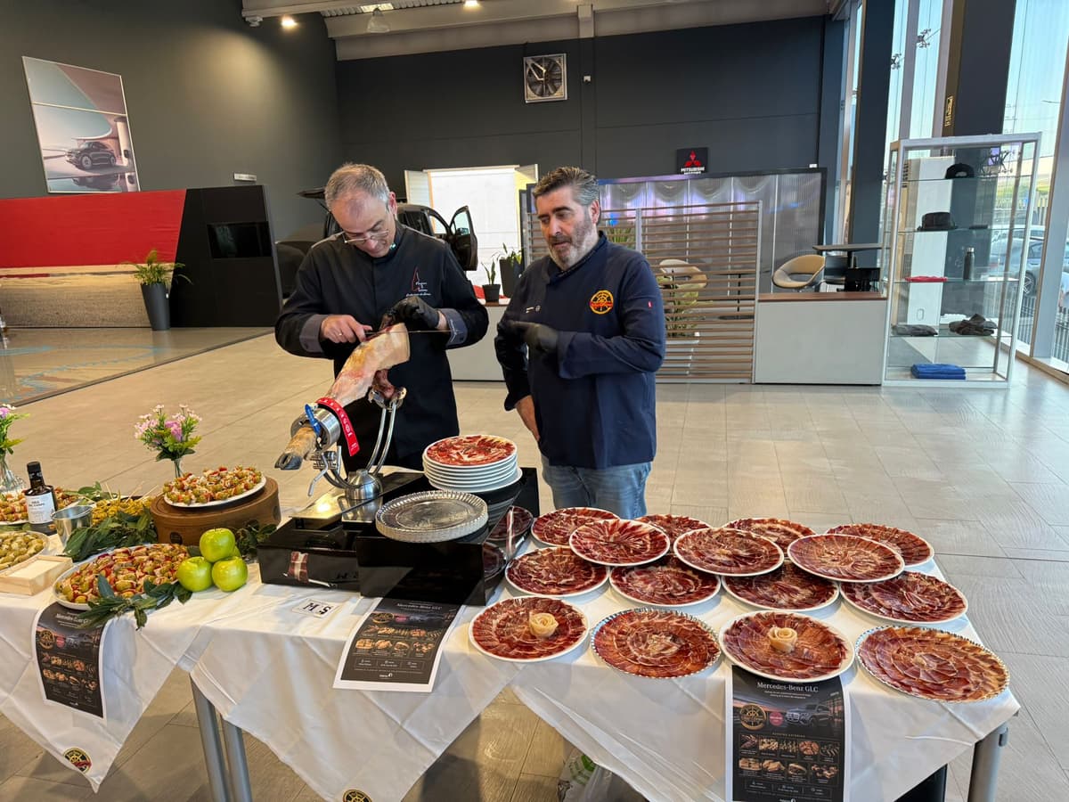 Dos cortadores de jamón sirviendo platos de ibérico en un catering de San Remo para una presentación de Mercedes-Benz
